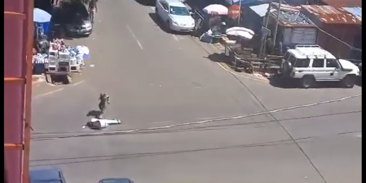 A screengrab from an amateur video shows the military officer standing over the motionless body of the gunman, shortly after dropping him down. Photo credit, Kemo Cham, ManoReporters