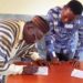 Chief Ismail Koroma, Chiefdom Speaker Small Bo Chiefdom, signing the by-law as District Medical Officer Dr Donald Grant looks on. Photo credit, James Flee, manoReporters