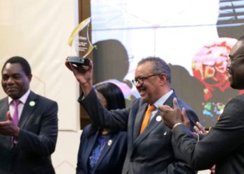 WHO Director-General Dr. Tedros Adhanom Ghebreyesus displays his award as Zambian President Hakainde Hitchilema claps