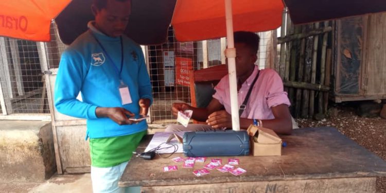 A customer makes mobile money transfer in the town of Sahn Malenin Pujehun District, Eastern Sierra Leone. Photo Credit Brima Sannoh ManoReporters.