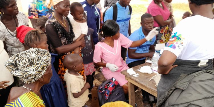 Residents of Kaboreh Village in Karene District line up to be tested for malaria by health workers as part of the Global Fund supported Static Campaign. Photo credit, Kemo Cham, ManoReporters.