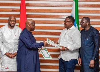 Foreign Ministers of Guinea and Sierra Leone, Morissanda Kouyate (in blue gown) and Timothy Musa Kabba, exchange signed documents committing Sierra Leone to provide its neighbor sustainable supply of petroleum products following last month’s oil depot explosion in Conakry. Photo credit, Office of the Prime of Guinea.