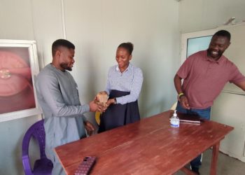 SLAES President Yusuf Kabba re ceived the cash from an official of Project 1808 as Prof. N'jai looks on.