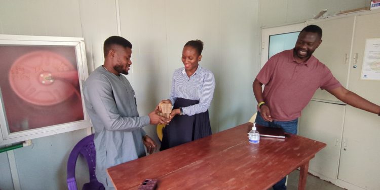 SLAES President Yusuf Kabba re ceived the cash from an official of Project 1808 as Prof. N'jai looks on.