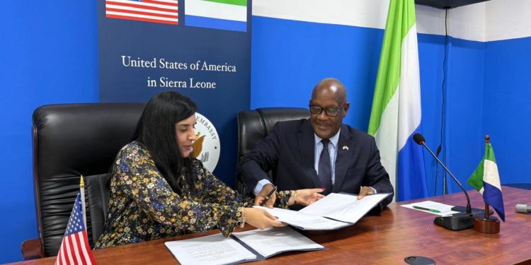 Sierra Leone's Minister of Health Dr Austin Demby exchanges signed copies of the agreement with the US Charge 'dAffairs during the signing ceremony at an in Freetown. Image, MoH Sierra Leone.